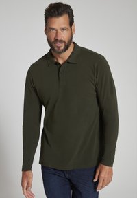 Langærmet, mørkegrøn polo skjorte med ribbet tekstur, tre-knaps lukkning og lige kant; parret med mørkeblå jeans.