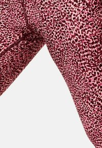 Lyserøde og maroon leggings med et leopardmønster. Lavet af strækbart stof, der har en glat tekstur og syede sømme.