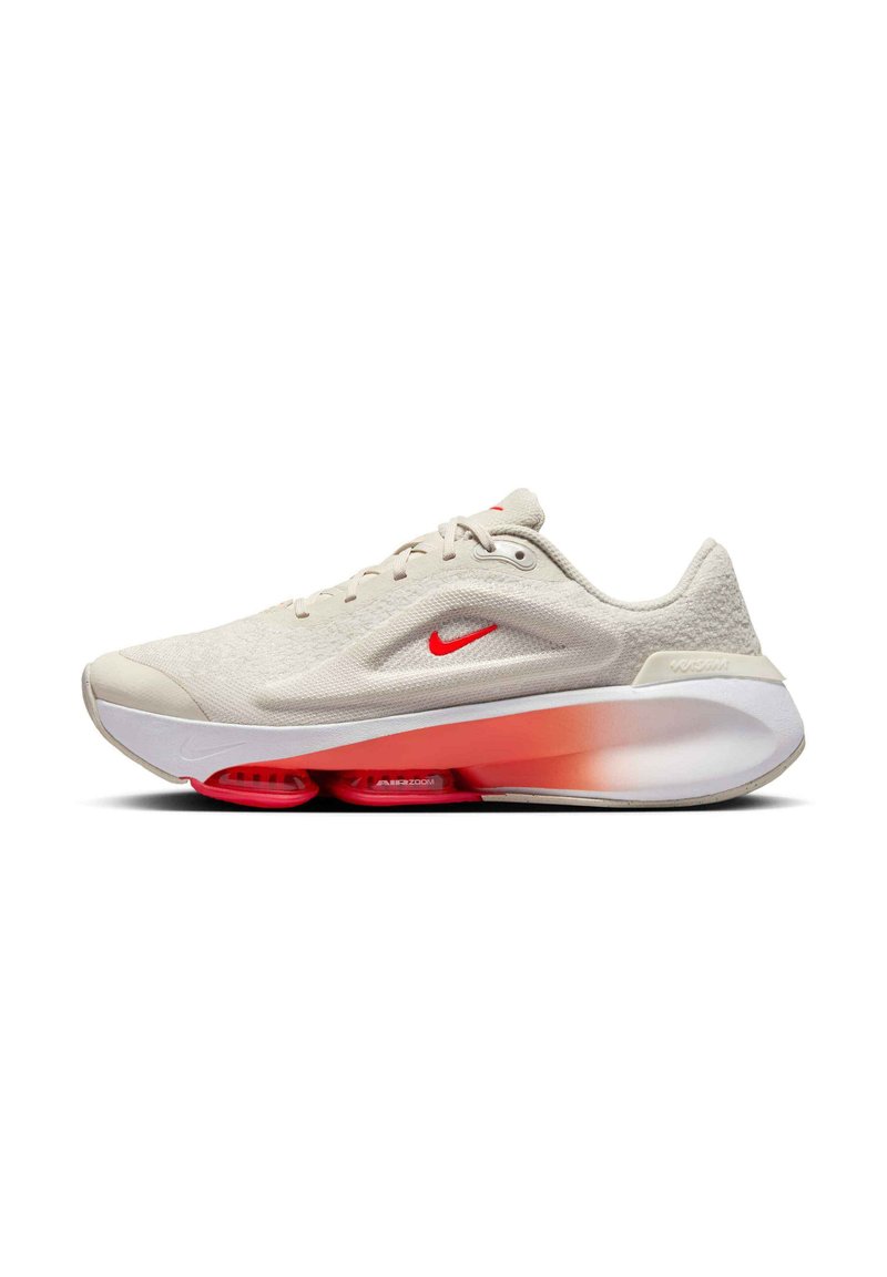 Gaišbeidzis Nike skriešanas apavs ar strukturētu virsu, sarkaniem akcentiem un gradienta oranžas līdz baltas krāsas zoli ar redzamu amortizāciju.