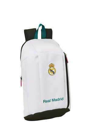 Biały plecak Real Madrid z czarną podstawą, zielonymi paskami na rączki, przednim zamkiem błyskawicznym oraz logo i nazwą klubu na przednim panelu.