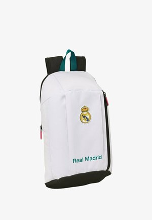Biały plecak Real Madrid z czarną podstawą, zielonymi paskami na rączki, przednim zamkiem błyskawicznym oraz logo i nazwą klubu na przednim panelu.