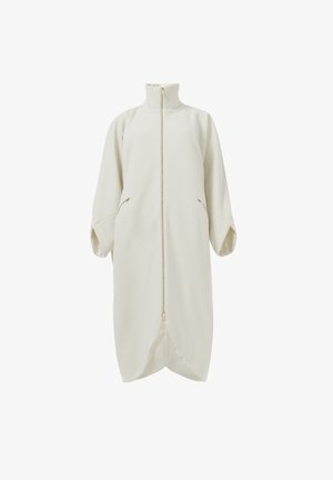 Manteau zip-up couleur crème avec un col montant, des manches surdimensionnées et des poches latérales. Tissu doux avec une texture lisse et un ourlet arrondi.