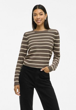Pull en maille rayé marron et crème avec un col et des poignets côtelés. Assorti avec un pantalon noir. Texture complexe avec une coupe décontractée.