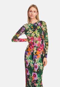 Blumenkleid mit langen Ärmeln und tailliertem Schnitt, das eine Mischung aus rosa, lila und orangefarbenen Blumen auf einem grünen Hintergrund und strukturierter Stoffqualität zeigt.