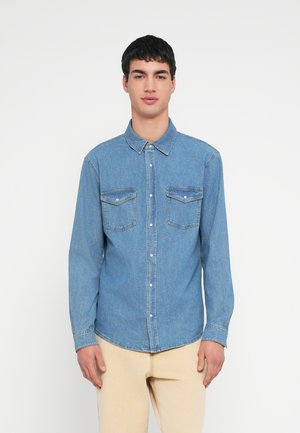 Hellblaues Denimhemd mit langen Ärmeln, durchgeknöpftem Vorderteil und zwei Brusttaschen. Verfügt über einen klassischen Kragen und eine lockere Passform.