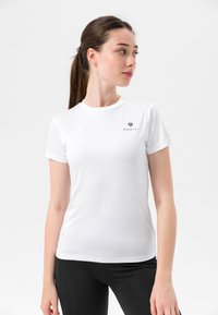 Hvit idretts t-skjorte laget av glatt stoff, med rund hals og korte ermer, med en svart logo trykket på brystet.