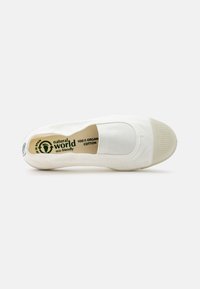Fehér slip-on cipő, 100%-ban organikus pamutból készült. Lapos gumitalp, texturált elülső résszel, a talpbetéten és az oldalon egyedi márkajelzéssel.