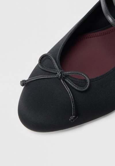 Čierna balerína z textilu s okrúhlou špičkou, obsahuje malý mašličkový detail vpredu a polstrovanú vínovočervenú stielku.