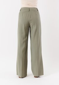 Pantaloni a gamba larga in tessuto verde oliva con una texture liscia, dotati di pinces frontali, vita aderente e un design leggermente a vita alta.
