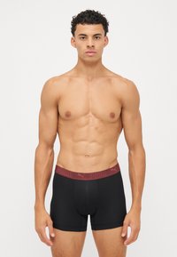 Boxeri negri cu un contur elastic vișiniu ce prezintă logo-ul "PUMA". Material moale, ajustat, proiectat pentru confort și mișcare.