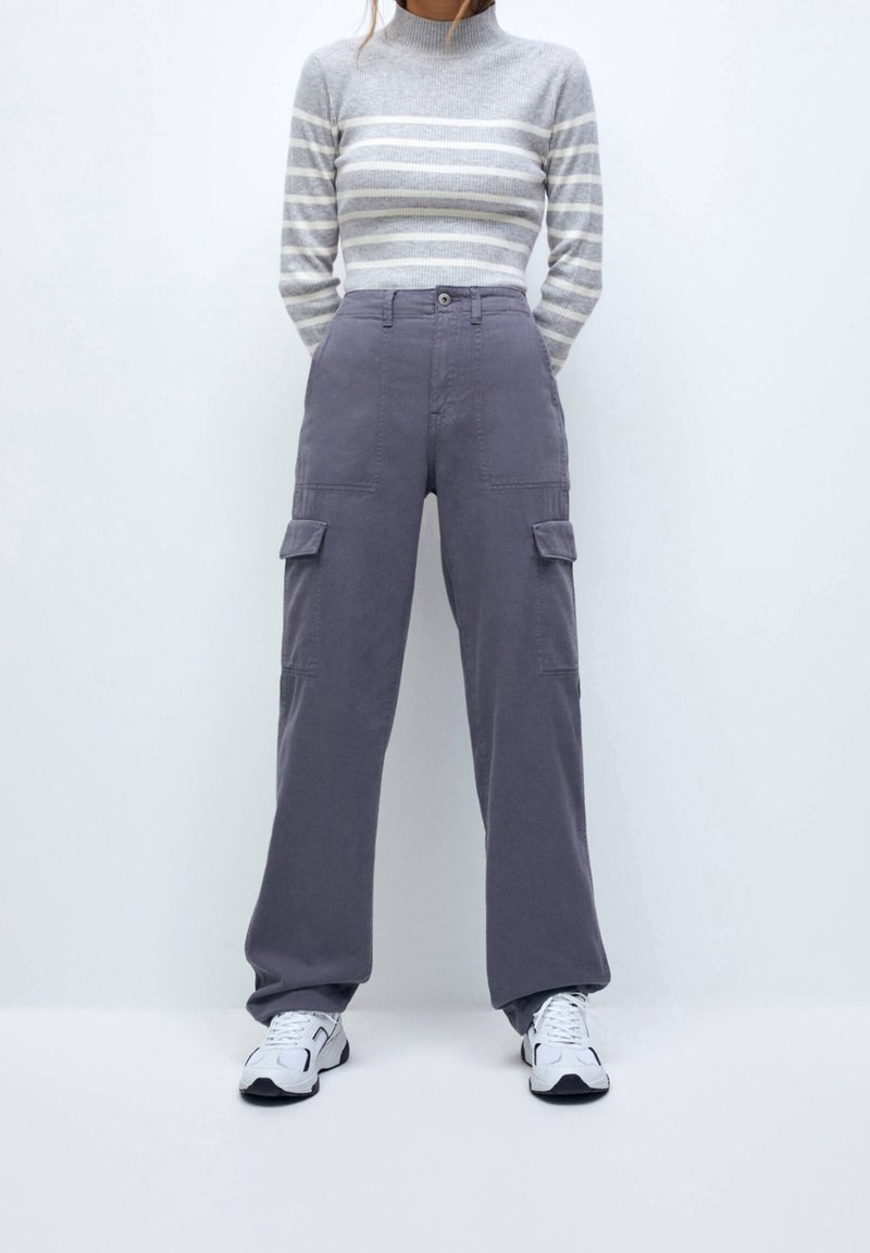 Cargo bukser i blødt gråt stof, med to forlommer, en afslappet pasform og høj talje. Sammen med en stribet tætsiddende turtleneck.