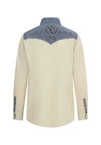 Camisa beige de manga larga con canesú, cuello y puños azules, con texto y logo bordados en la parte superior de la espalda.