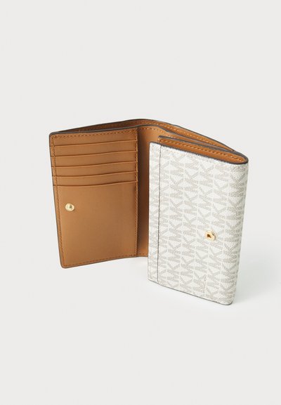 Portefeuille avec un revêtement en tissu texturé de couleur claire présentant un motif subtil, et un intérieur en cuir marron lisse avec plusieurs emplacements pour cartes.