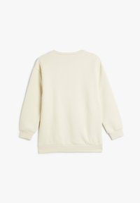 Sudadera de color crema con un ajuste relajado, cuello redondo, hombros caídos, y puños y dobladillo acanalados. Material suave de mezcla de algodón.