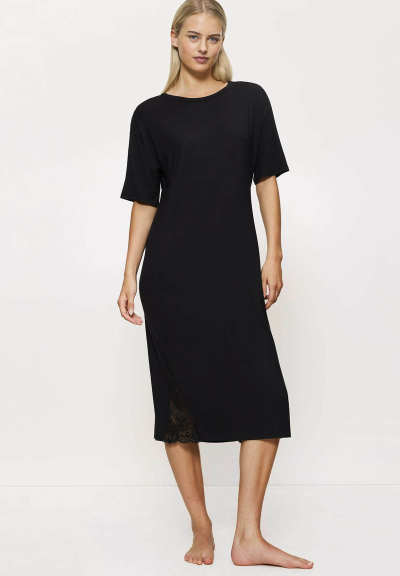 Czarna sukienka do kolan z krótkimi rękawami i okrągłym dekoltem. Posiada koronkowe detale na bocznym szwie, co dodaje tekstury. Wykonana z miękkiego materiału.