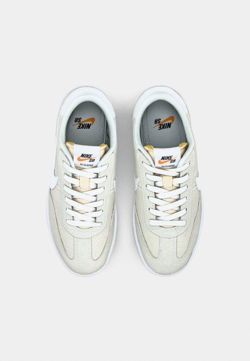 Zapatillas Nike SB Classic en ante y cuero color crema con acentos blancos, cordones planos y una lengüeta acolchada que presenta detalles del logo.