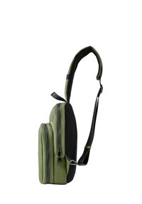Grön syntetisk axelväska med ett strukturerat svart nätband. Har två zippered fack, en stilren design och minimal hardware.