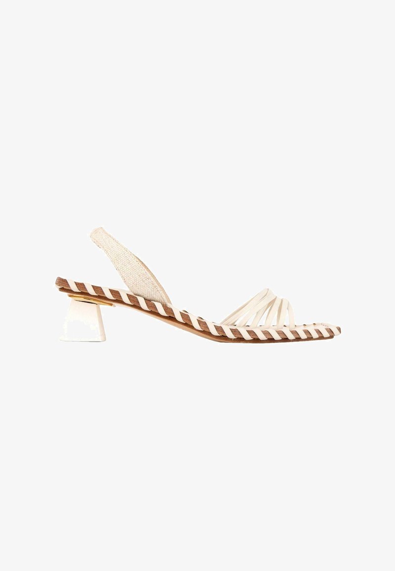 Sandale beige à bride arrière avec plusieurs fines lanières aux orteils, semelle marron avec bordure tressée blanche, et petit talon bloc blanc.