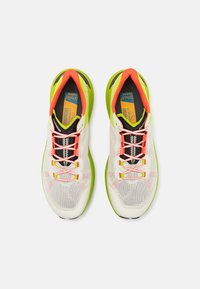 Scarpe sportive con tomaia in rete bianca, dettagli arancioni e verdi, chiusura con lacci e suola testurizzata per la presa.