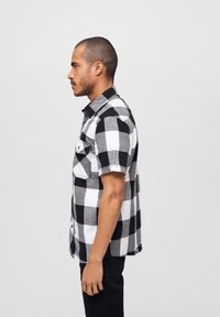 Korte mouwen geruite blouse in zwart en wit met een button-down kraag, borstzakken en een relaxte pasvorm. Gemaakt van katoen.