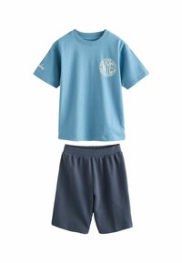 T-shirt en coton bleu clair avec logo NYC sur la poitrine, assortie à un short de sport gris foncé avec taille élastique.