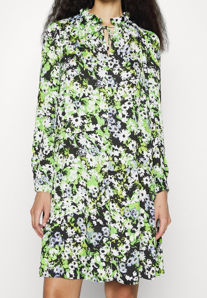 Long-sleeve dress in black, adorned with a floral pattern in green, white, and blue. Features a ruffled neckline and a keyhole opening.