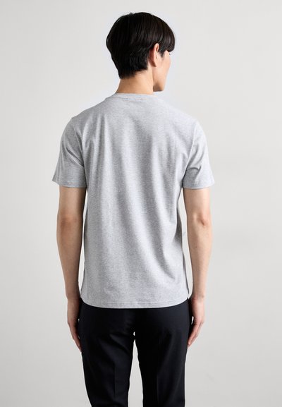 T-shirt gris à manches courtes, en coton doux, avec un col rond et une coupe décontractée, présentant une texture lisse et sans motifs visibles.