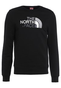 Černá mikina vyrobená z bavlny, s kulatým výstřihem, dlouhými rukávy a velkým stříbrným logem s obloukovým designem na přední straně.