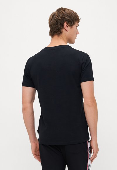 T-shirt preta de manga curta feita de algodão. Design com gola redonda e textura suave. Parte de trás simples, sem padrões ou acentos adicionais.
