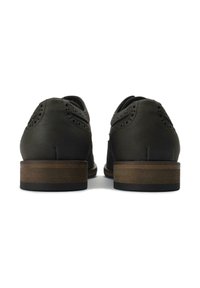 Dark green leather shoes with a brogue design, featuring perforated details and a wooden block heel. Smooth texture.