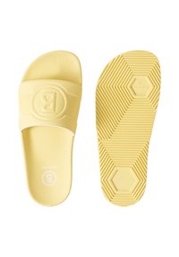 Paire de sandales à glissière jaune pâle, l'une montrant la semelle intérieure texturée et la bride avec logo embossé, l'autre montrant la semelle à motifs avec la taille et l'origine.