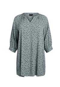 Grön blommig blus med V-ringning och trekvarts puffärm. Lättviktig tyg med ett litet blommönster genom hela.