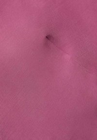 Tessuto rosa pallido, solido, con una texture liscia, caratterizzato da una leggera piega e un dettaglio di puntino al centro.