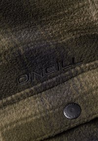 Fleece stof i mørkegrøn og sort plaid med en mat tekstur. Har et sort præget "ONEILL" logo og en sort trykknapdetalje.
