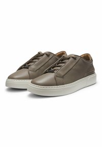 Un paio di sneaker in pelle marrone con texture, dotate di suole spesse bianche e lacci marroni abbinati, mostrati in una vista frontale angolata.