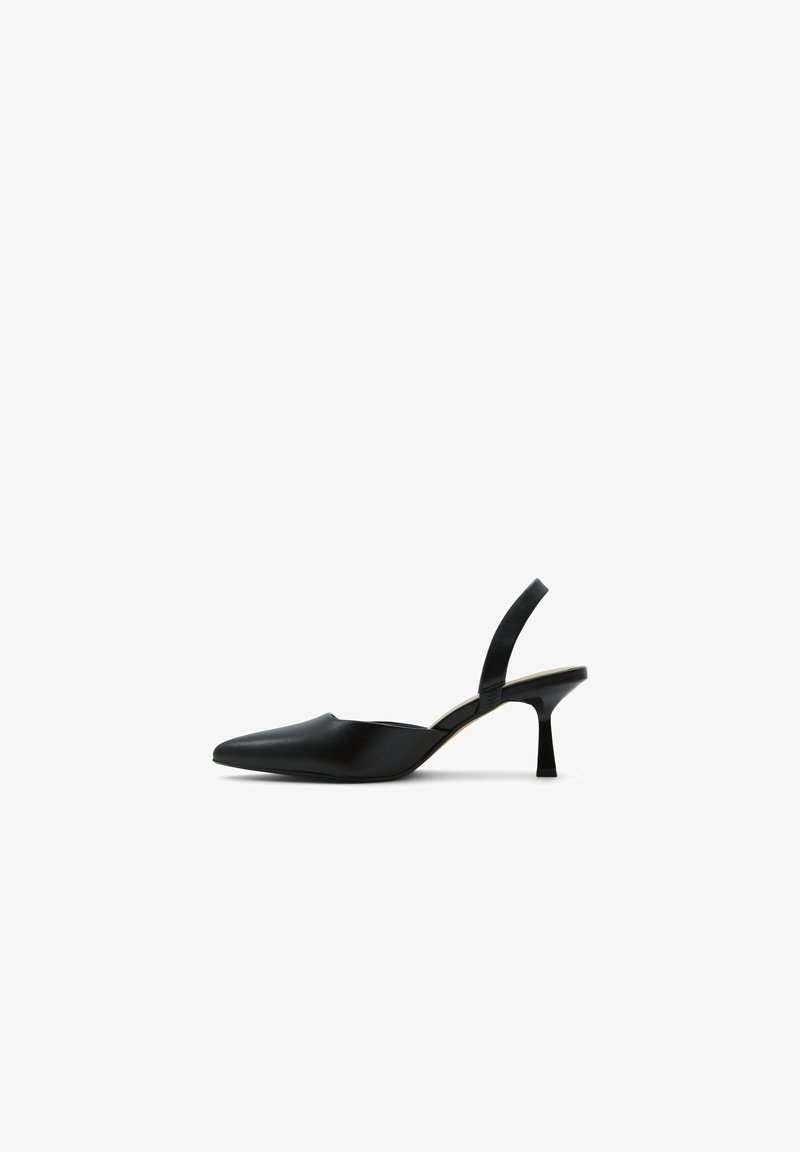 Chaussure slingback noire à bout pointu avec un petit talon évasé contre un fond blanc.