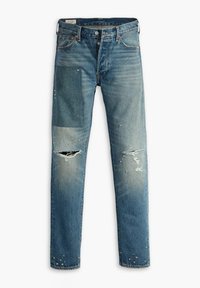 Jeans de mezclilla de color azul claro con parches, áreas desgastadas y adornos de tachuelas plateadas. Diseño de pierna recta y estilo tradicional de cinco bolsillos.