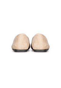 Beige suède ballerina's met een lage zwarte rubberen zool, voorzien van een gladde, taps toelopende neus en minimale stiksels aan de achterkant.