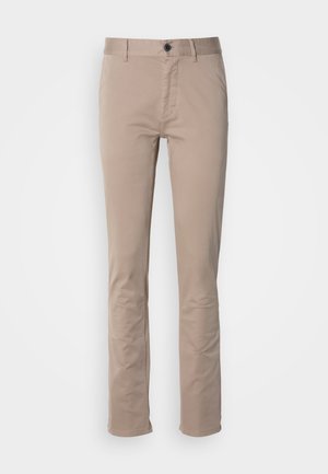 Chinos beige in cotone con design a vita piatta, vestibilità dritta e classico stile a cinque tasche. Presentano una chiusura con un singolo bottone.