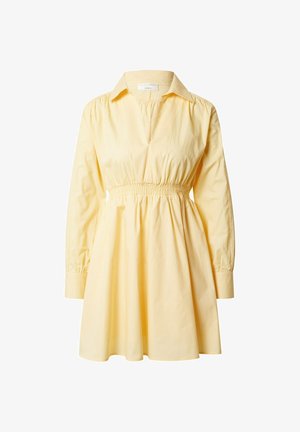Żółta bawełniana sukienka z kołnierzykiem, długimi bufiastymi rękawami i marszczoną talią. Spódnica delikatnie rozszerza się od talii.