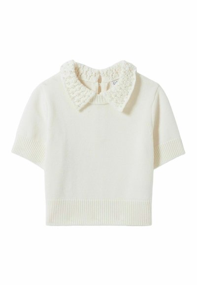 Suéter corto de manga corta en color crema. Presenta un cuello texturizado de punto con acentos de cuentas. Dobladillo ribeteado y puños de las mangas ribeteados.