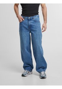 Light blue denim trousers with a loose fit, featuring a standard waistband, four pockets, and slightly frayed hems. Suitable for casual wear.