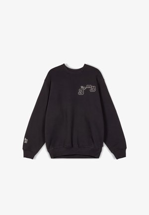 Sudadera negra de cuello redondo hecha de una tela suave. Presenta un gráfico en contraste en el pecho y un detalle del logo en la manga.