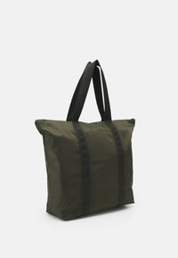 Sac fourre-tout rectangulaire vert foncé avec des anses noires et une fermeture éclair, posé debout sur un fond blanc.