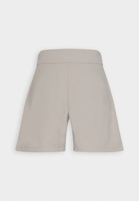 Beige Shorts aus weichem Material, mit breitem elastischem Bund und Seitentaschen, glatter Textur und knielangem Schnitt.