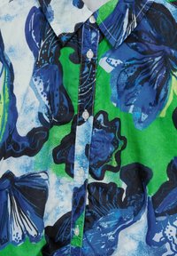 Kurzarmhemd mit einem bunten Blumenmuster in Blau und Grün, mit einer Knopfleiste und leichtem Stoff.