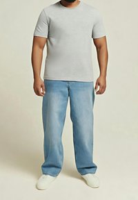 Šedé tričko s krátkým rukávem v kombinaci se světle modrými volnými džíny a bílými botami, s jednoduchým designem a jemnou texturou.
