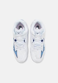 Baskets de sport blanches avec des accents bleus, tige en mesh pour la respirabilité, col rembourré et semelle texturée pour l'adhérence.