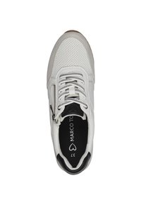 Chaussure de sport blanche avec partie supérieure perforée, accents gris, talon noir et fermeture éclair. Semelle intérieure noire avec marque visible. Semelle plate en caoutchouc.