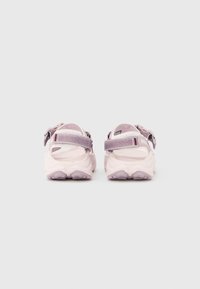 Ανοιχτό μωβ σανδάλια με ρυθμιζόμενα λουριά, υφή στο πέλμα και ανθεκτική ελαστική σόλα. Μινιμαλιστικός σχεδιασμός με ανοιχτή φτέρνα και λεπτομέρειες για καλύτερο κράτημα.